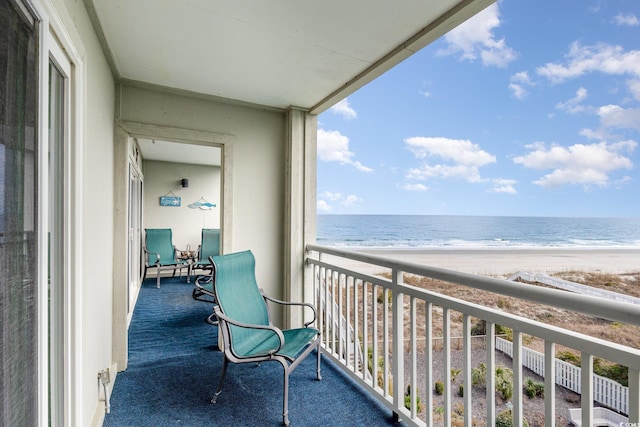 balcony featuring a water view and a view of the beach