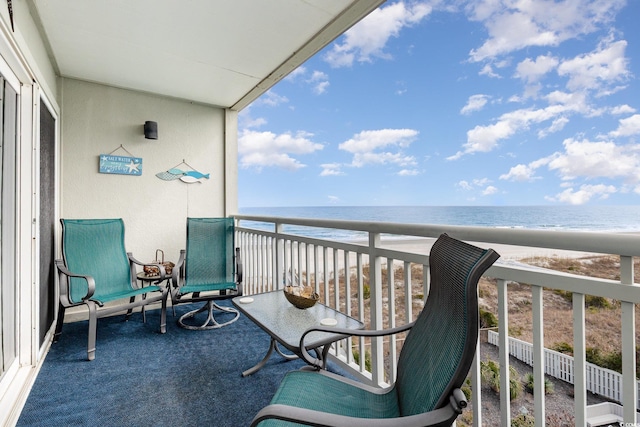 balcony featuring a view of the beach and a water view