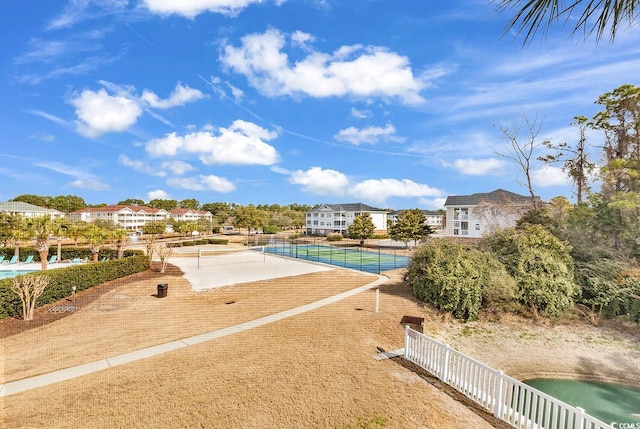 view of pool with a water view and a tennis court