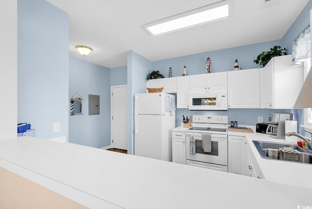 kitchen featuring white cabinets, white appliances, light countertops, and a sink