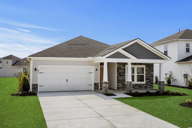 4295 Falls Oaks St, Myrtle Beach, SC 29579 - view of front facade with stone siding, a garage, concrete driveway, a front lawn, and a shingled roof