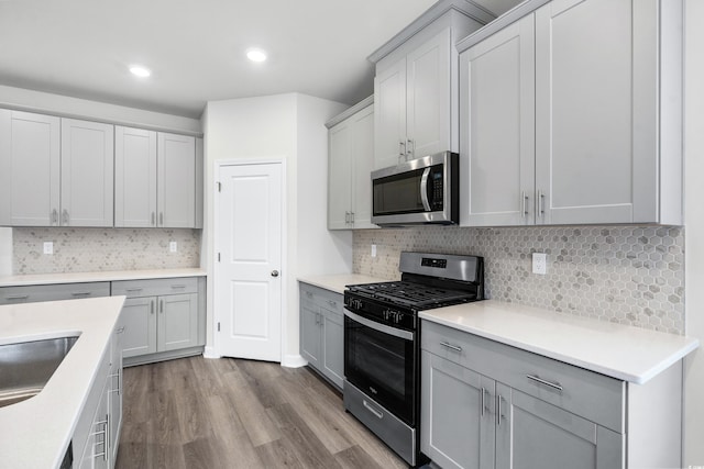 4295 Falls Oaks St, Myrtle Beach, SC 29579 - kitchen with light countertops, stainless steel appliances, gray cabinetry, decorative backsplash, and wood finished floors