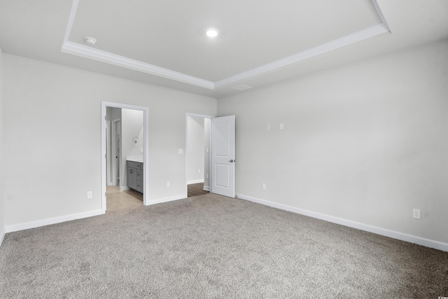 4295 Falls Oaks St, Myrtle Beach, SC 29579 - unfurnished bedroom featuring light carpet, baseboards, ensuite bath, and a tray ceiling