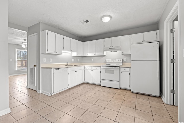 kitchen featuring visible vents, under cabinet range hood, a sink, white appliances, and light countertops