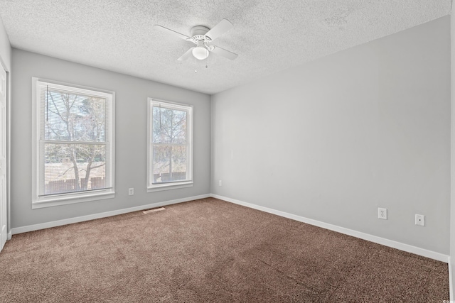 carpeted empty room featuring visible vents, a textured ceiling, a ceiling fan, and baseboards