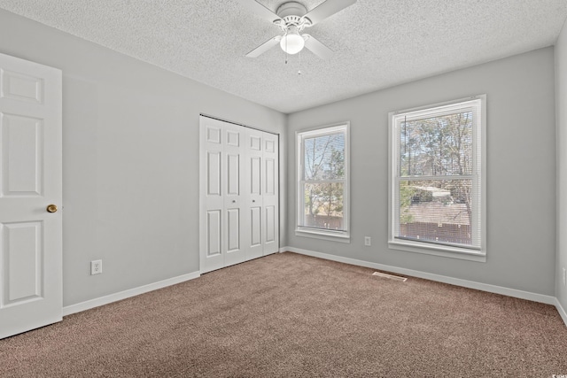 unfurnished bedroom featuring a closet, carpet flooring, visible vents, and baseboards