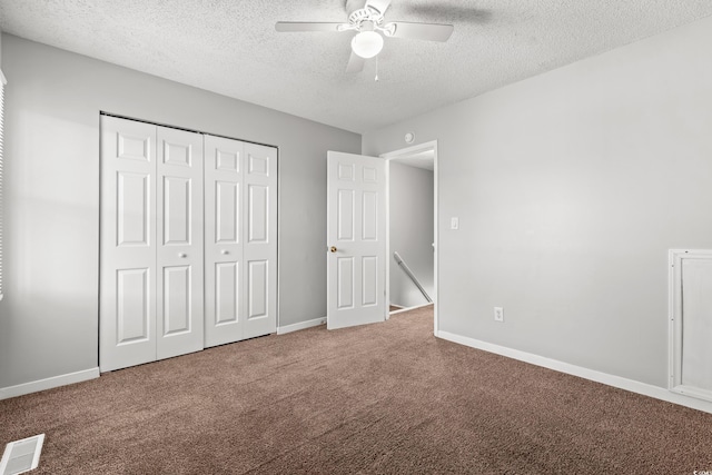 unfurnished bedroom with visible vents, baseboards, carpet floors, a closet, and a textured ceiling