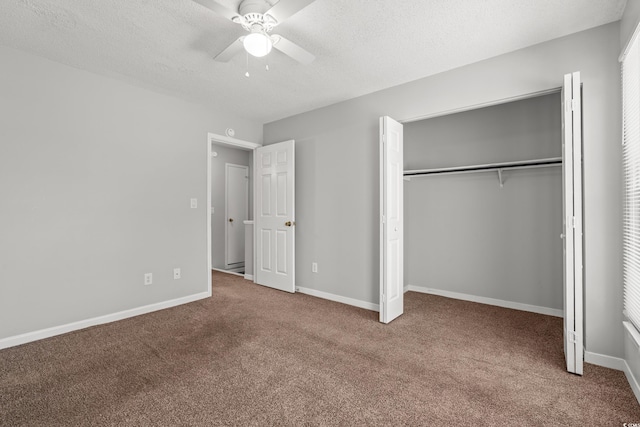 unfurnished bedroom featuring baseboards, carpet flooring, a closet, a textured ceiling, and a ceiling fan