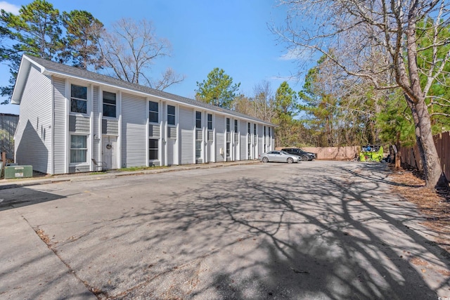 view of building exterior featuring central AC and fence