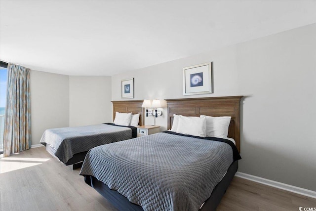 bedroom featuring wood finished floors and baseboards