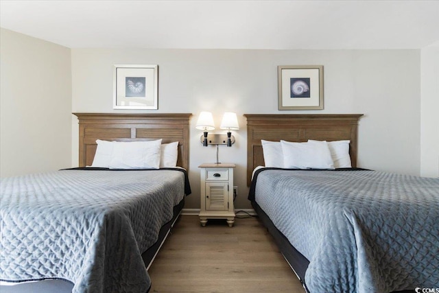 bedroom with baseboards and wood finished floors