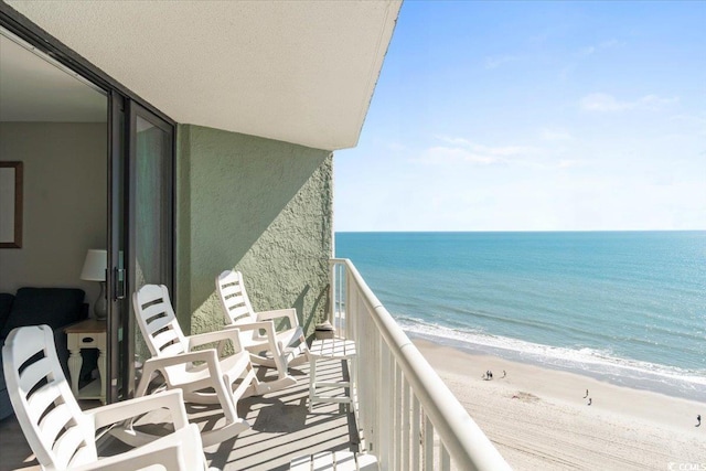 balcony featuring a water view and a beach view