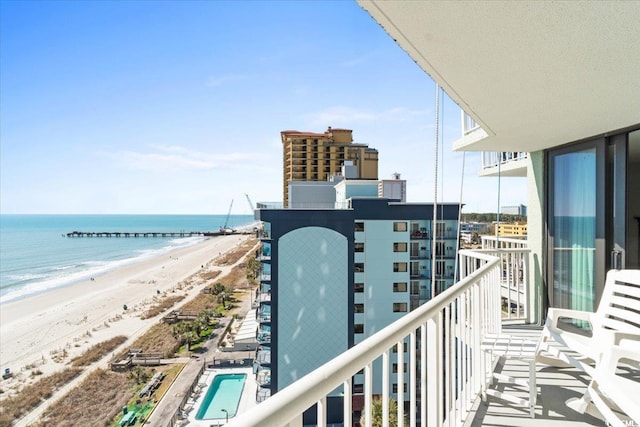 balcony featuring a water view and a view of the beach