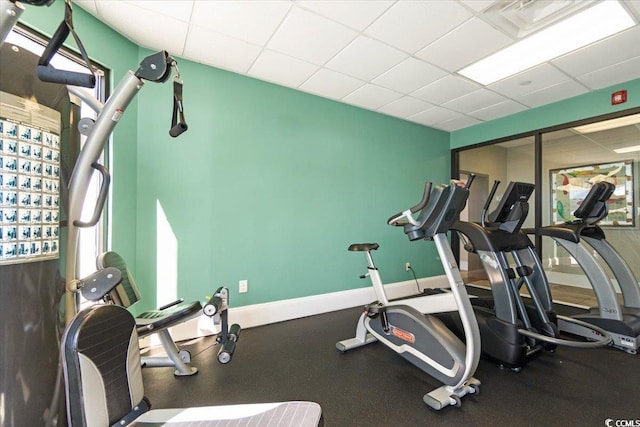 workout area with a drop ceiling and baseboards