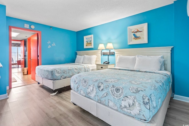 201 S Ocean Blvd Unit 217, Myrtle Beach, SC 29577 - bedroom with wood finished floors, a textured ceiling, and baseboards