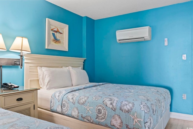 201 S Ocean Blvd Unit 217, Myrtle Beach, SC 29577 - bedroom with a wall mounted AC, wood finished floors, and baseboards