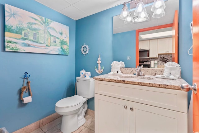 201 S Ocean Blvd Unit 217, Myrtle Beach, SC 29577 - bathroom featuring toilet, tile patterned flooring, vanity, baseboards, and backsplash