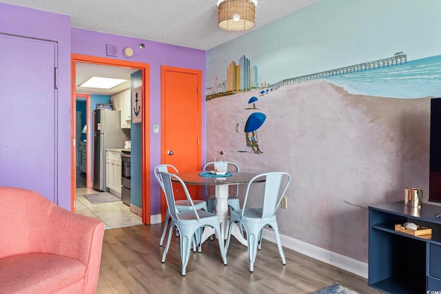 201 S Ocean Blvd Unit 217, Myrtle Beach, SC 29577 - dining area with light wood-style flooring and a textured ceiling