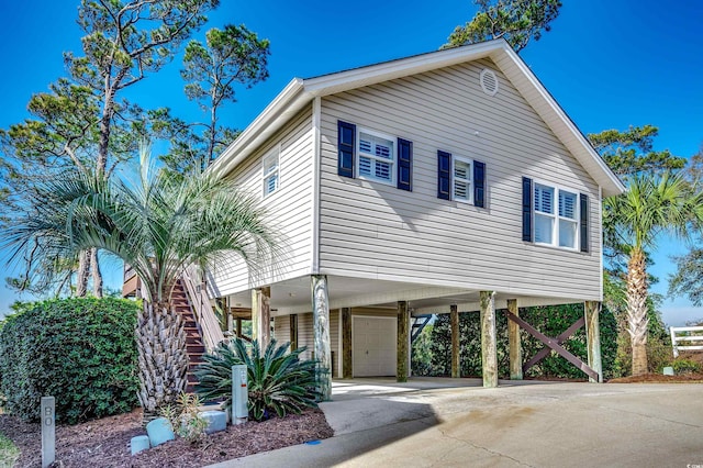 view of front of property with a carport, an attached garage, and stairs