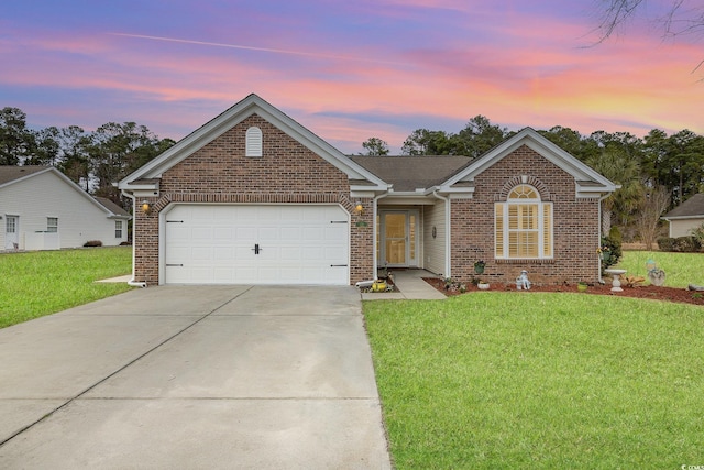 ranch-style home with a yard, driveway, a garage, and brick siding