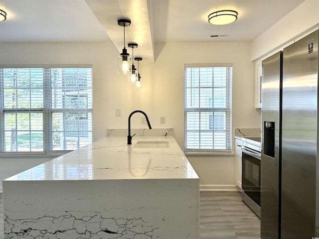 5000 Windsor Green Way Unit 204, Myrtle Beach, SC 29579 - kitchen with stainless steel appliances, a sink, a peninsula, light wood-style floors, and baseboards