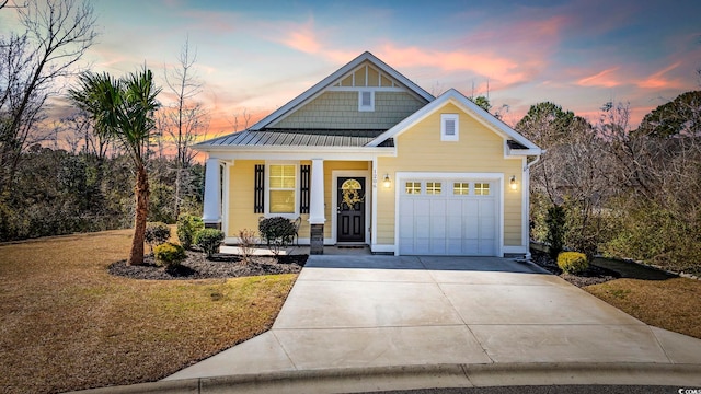 craftsman inspired home featuring a porch, concrete driveway, an attached garage, a standing seam roof, and metal roof