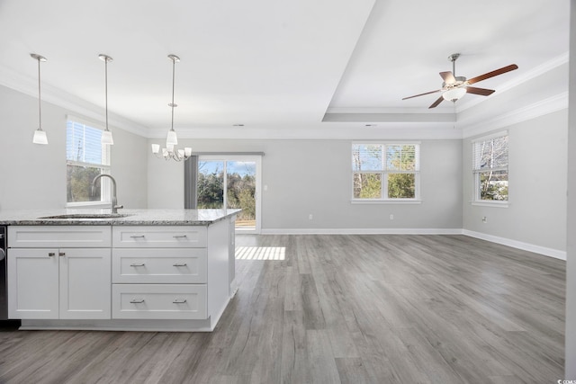 kitchen with a wealth of natural light, open floor plan, a sink, and light wood finished floors