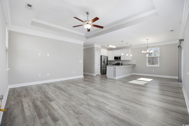 unfurnished living room featuring ceiling fan with notable chandelier, ornamental molding, a raised ceiling, and light wood-style floors