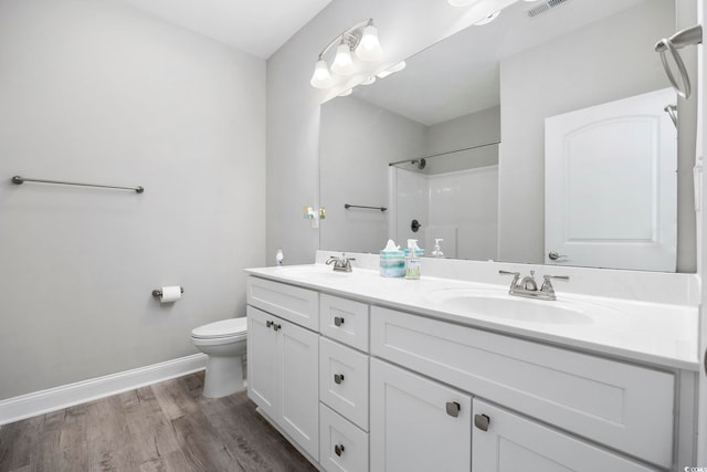 bathroom with toilet, baseboards, a sink, and wood finished floors