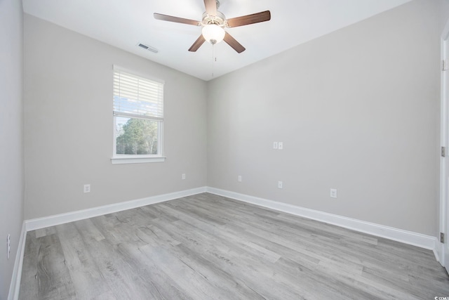 empty room with light wood finished floors, baseboards, visible vents, and a ceiling fan