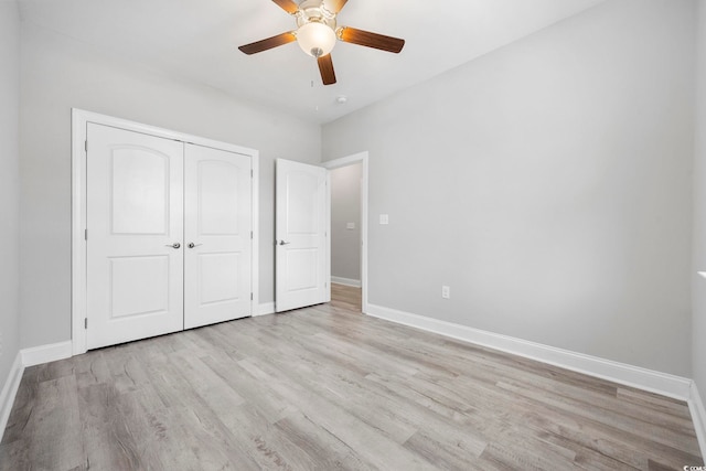 unfurnished bedroom featuring a ceiling fan, light wood-style flooring, baseboards, and a closet