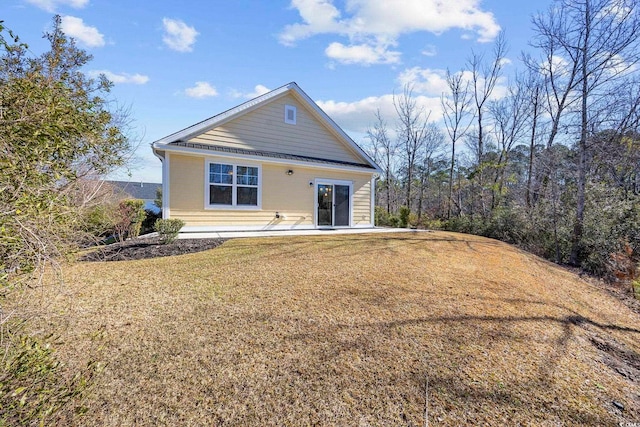 back of property featuring a lawn and a patio