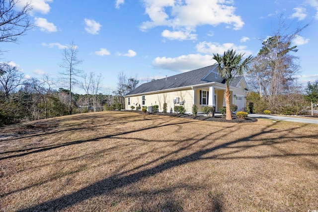 view of property exterior with a garage and a lawn