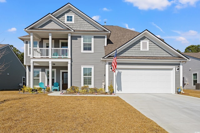 view of front of property featuring driveway, roof with shingles, an attached garage, a front yard, and a balcony