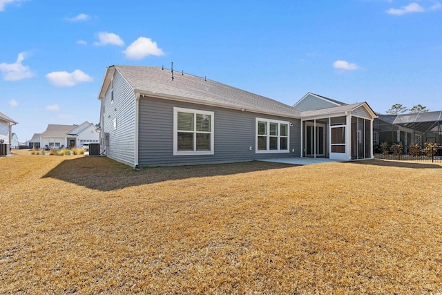 rear view of property featuring a yard and a sunroom