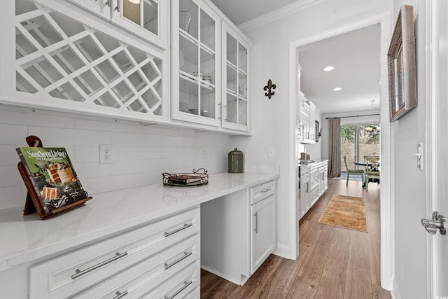 bar featuring wood finished floors, an inviting chandelier, recessed lighting, decorative backsplash, and crown molding