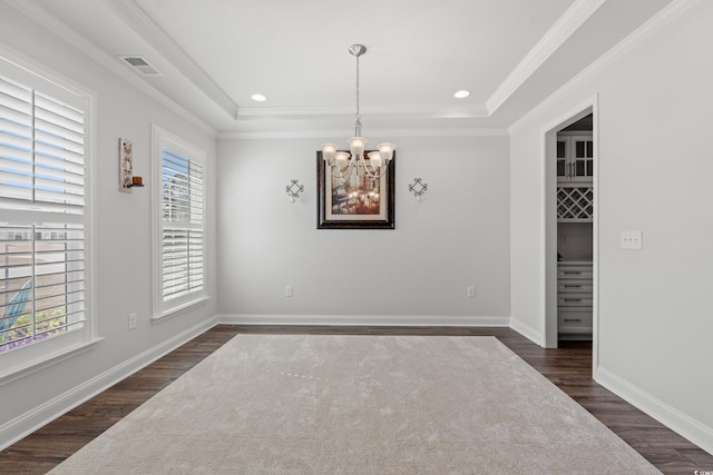 empty room featuring visible vents, a raised ceiling, baseboards, and dark wood-style floors