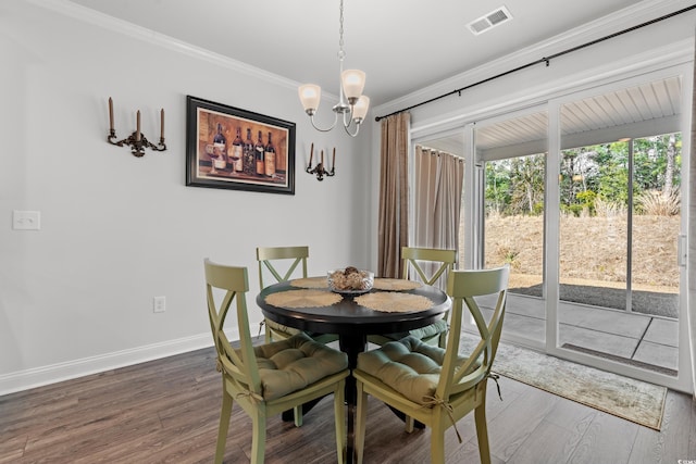 dining space with wood finished floors, baseboards, visible vents, an inviting chandelier, and ornamental molding