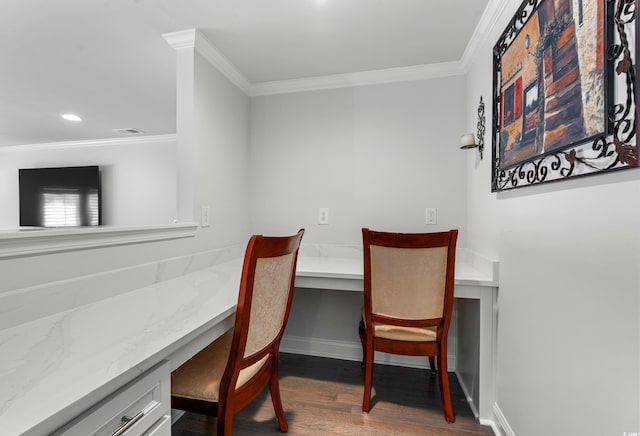 office area featuring wood finished floors, built in study area, visible vents, and ornamental molding