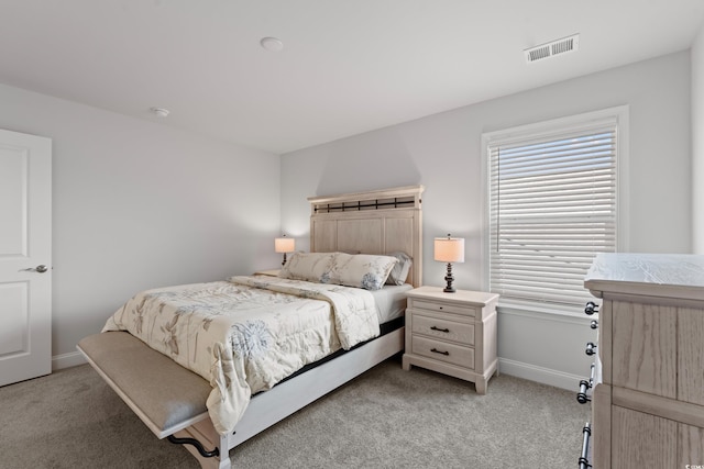 bedroom featuring visible vents, light colored carpet, and baseboards