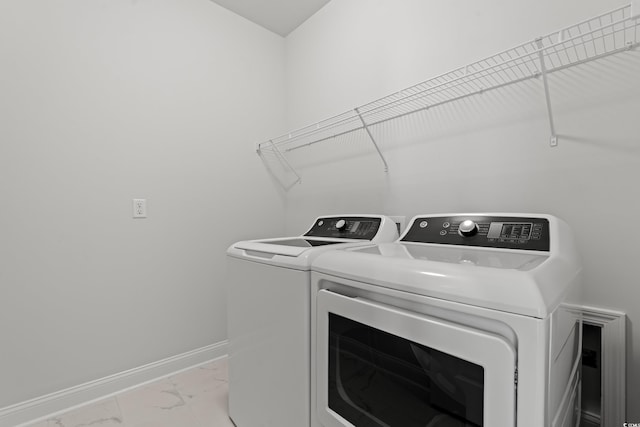 washroom with laundry area, marble finish floor, baseboards, and separate washer and dryer