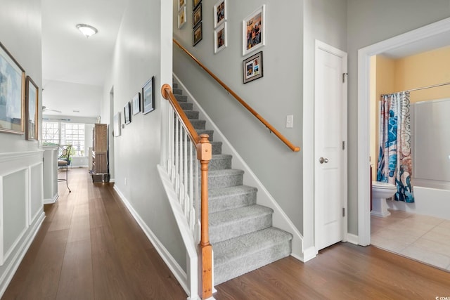 staircase with wood finished floors and baseboards