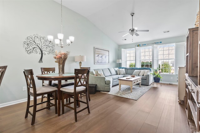 interior space featuring ceiling fan with notable chandelier, dark wood finished floors, visible vents, and baseboards