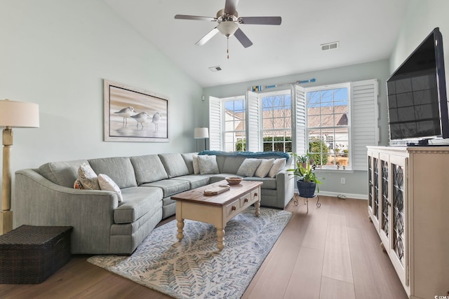 living room featuring lofted ceiling, a ceiling fan, visible vents, and wood finished floors