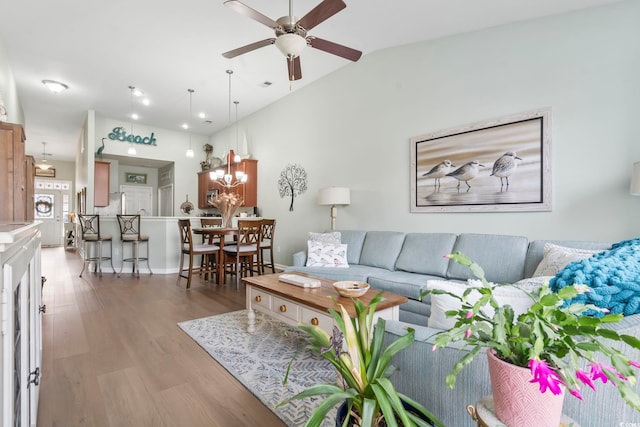 living room with ceiling fan, wood finished floors, visible vents, and lofted ceiling