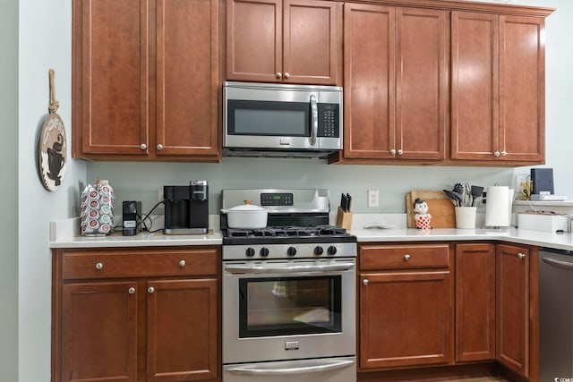 kitchen with appliances with stainless steel finishes, brown cabinets, and light countertops