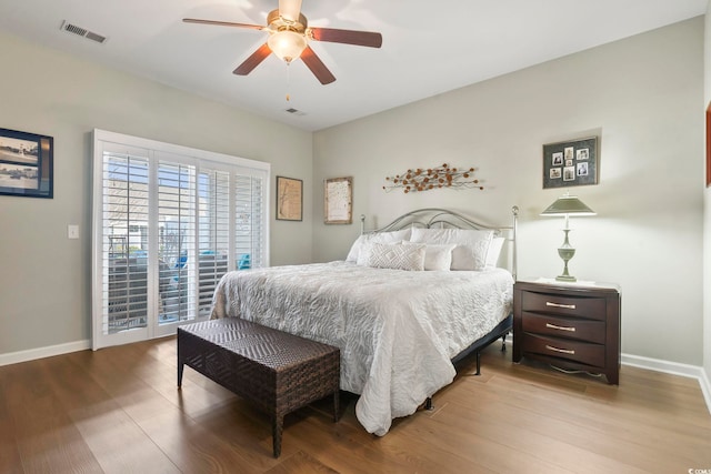 bedroom with access to exterior, visible vents, baseboards, and wood finished floors