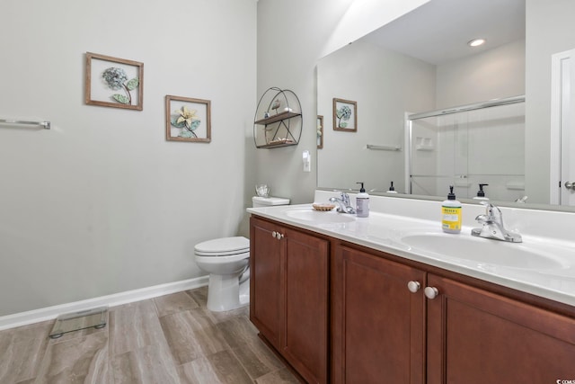 full bathroom featuring a stall shower, a sink, toilet, and double vanity