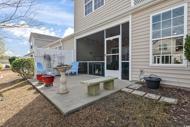 view of patio / terrace with fence and a sunroom