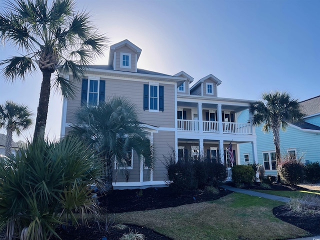 view of front of house with a balcony and a front lawn